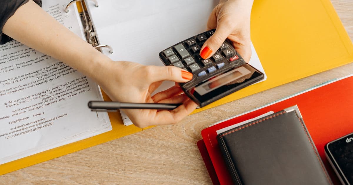 Cálculo de costes y márgenes con calculadora y documentación sobre una mesa